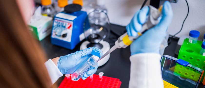 A scientist pipettes liquid into a beaker