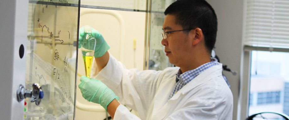 MCC scientist Zhi-Xiong Ma inspects a vial in the chemical hood